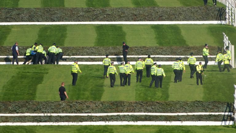 Police officers respond to Animal Rising activists attempting to invade the race course ahead of the Randox Grand National Handicap Chase during day three of the Randox Grand National Festival at Aintree Racecourse, Liverpool. A report said protesters planned to form a human barricade across the track at Aintree after sneaking into the event with ladders and bolt cutters. Picture date: Saturday April 15, 2023.

